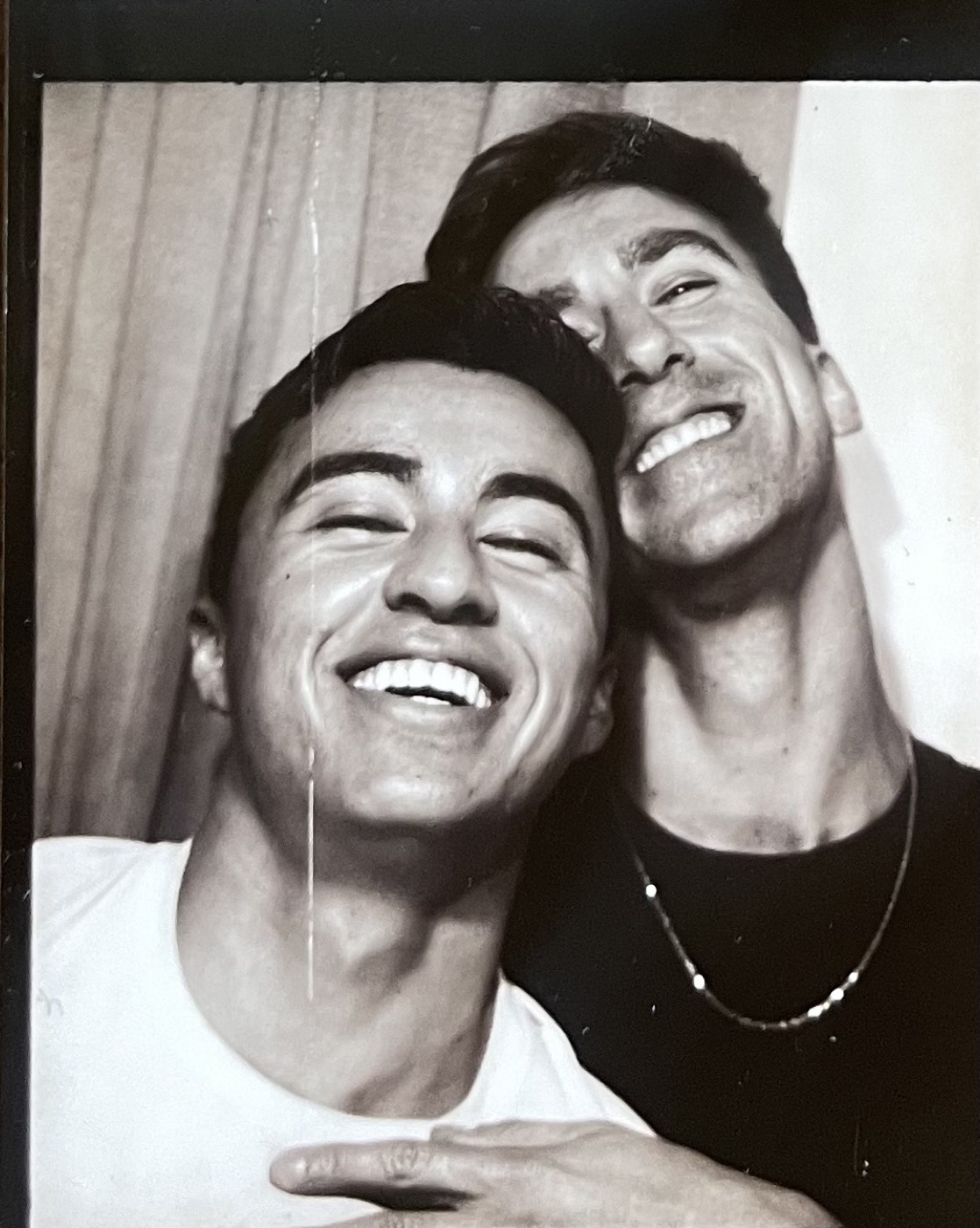 Black and white photobooth frame, two big mid-laugh smiles